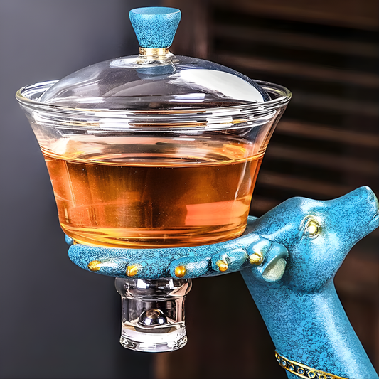 Glass teapot with wooden deer stand, filled with tea.