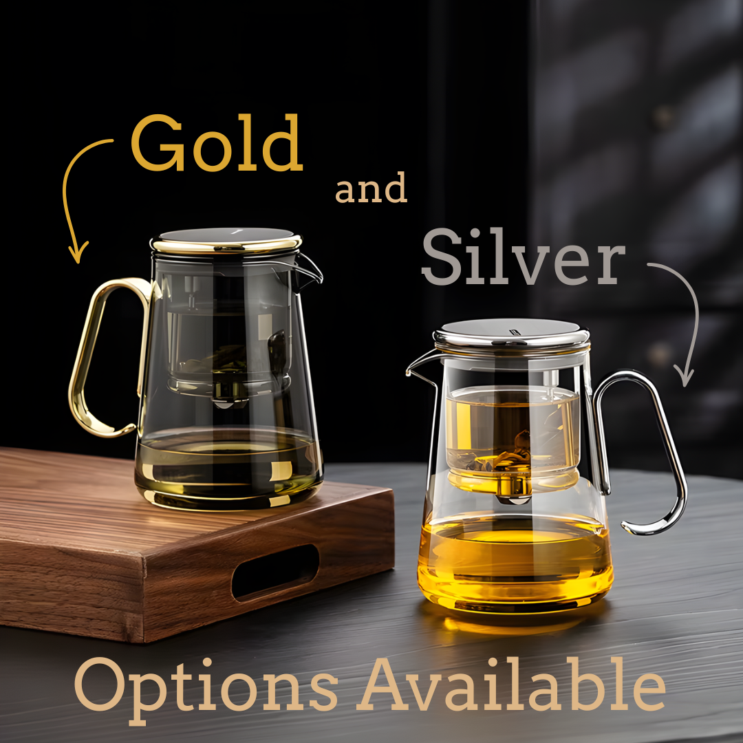 Two clear glass teapots with gold and silver handles